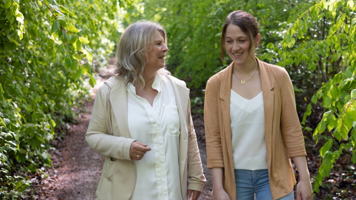 Daniela Brandl im Naturcoaching-Gespräch mit einer Klientin auf einem Waldweg in Bergisch Gladbach